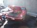 2002 Ford Mustang - A classic red Mustang is displayed with its hood open, parked beside a newer model.