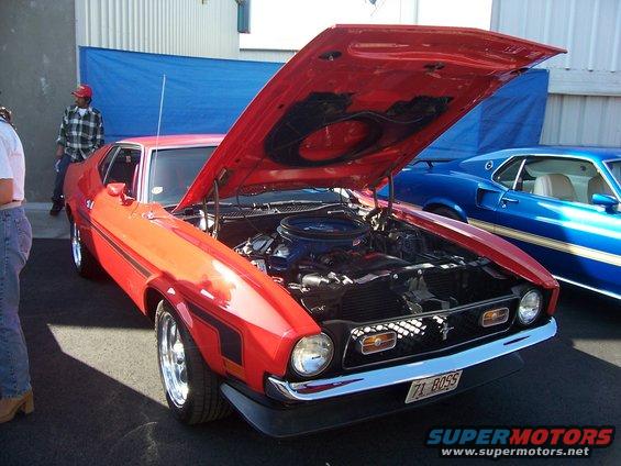 Red 1971 Ford Mustang Mach 1 with hood open, showing engine. License plate reads '71 BOSS'