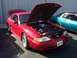 2002 Ford Mustang - A red Ford Mustang is parked with its hood and trunk open, revealing the engine and rear spoiler.