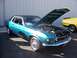 2002 Ford Mustang - This teal 1969 Ford Mustang coupe features a black vinyl roof and wire wheels, with its hood open to display the engine.