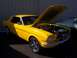 2002 Ford Mustang - A yellow 1965 Ford Mustang coupe is displayed with its hood open, parked next to another vehicle.