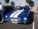 2002 Ford Mustang - A classic blue and white striped car is parked next to another vehicle.