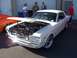 2002 Ford Mustang - A classic white 1965 Ford Mustang coupe is displayed with its hood open, revealing the engine bay.