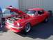 2002 Ford Mustang - A red 1965 Ford Mustang coupe is displayed with its hood open, revealing the engine bay.