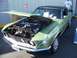 2002 Ford Mustang - A classic green 1969 Ford Mustang coupe is displayed with its hood open, revealing the engine bay.