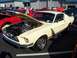 2002 Ford Mustang - A cream 1967 Ford Mustang fastback is displayed with its hood open, revealing the engine bay.