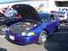 2002 Ford Mustang - A blue coupe with its hood open is displayed at an outdoor event with other vehicles.