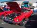 2002 Ford Mustang - A red classic Mustang is displayed with its hood open at an outdoor car show. Other vehicles are visible in the background.