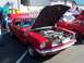 2002 Ford Mustang - A classic red Ford Mustang is displayed with its hood open, revealing a modified engine bay.