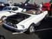 2002 Ford Mustang - White 1967-1968 Ford Mustang convertible displayed with hood open at an outdoor car show.