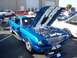 2002 Ford Mustang - A classic blue Ford Mustang with its hood open, displayed at an outdoor event with other vehicles.