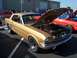 2002 Ford Mustang - A gold 1965 Ford Mustang coupe is displayed with its hood open, revealing the engine bay.