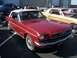 2002 Ford Mustang - Classic red convertible and a gold coupe are parked at an outdoor car show.