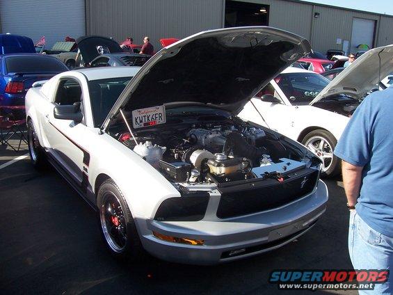 Silver Ford Mustang with hood open, showing engine. California license plate KWTK6FR visible