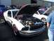 2002 Ford Mustang - A silver Ford Mustang is displayed with its hood open, revealing the engine compartment. Other cars are visible in the background.