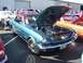 2002 Ford Mustang - A teal 1965 Ford Mustang coupe is displayed with its hood open at an outdoor car show.