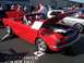 2002 Ford Mustang - This red 1965 Ford Mustang convertible is on display with its hood open, revealing the engine bay.