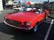2002 Ford Mustang - A red convertible classic car is parked next to a white classic car.