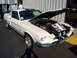 2002 Ford Mustang - A white 1967 Shelby GT500 is displayed with its hood open, revealing the engine and a binder of photos.
