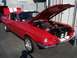2002 Ford Mustang - A red 1967 Ford Mustang fastback is displayed with its hood open, revealing the engine bay.
