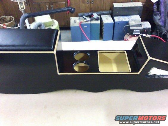 Custom black center console with two cupholders and a recessed tray