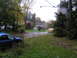 2003 Mazda Protege - Two cars are parked in a driveway on a wet, overcast day with autumn leaves on the ground.