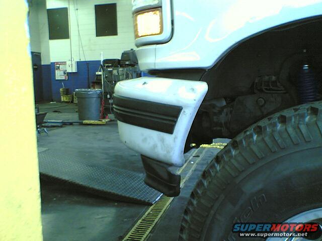 White 1996 Ford Bronco front fender and tire with black trim