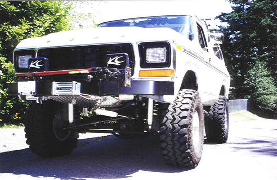 Front view of a lifted 1979 Ford Bronco with KC lights and a winch