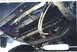 1979 Ford Bronco - Vehicle's undercarriage with transmission cooler and associated plumbing visible.