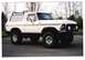 1979 Ford Bronco - This white Ford Bronco is equipped with a roof rack and large off-road tires.