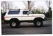 1979 Ford Bronco - This white 1979 Ford Bronco features a roof rack and is lifted with off-road tires.
