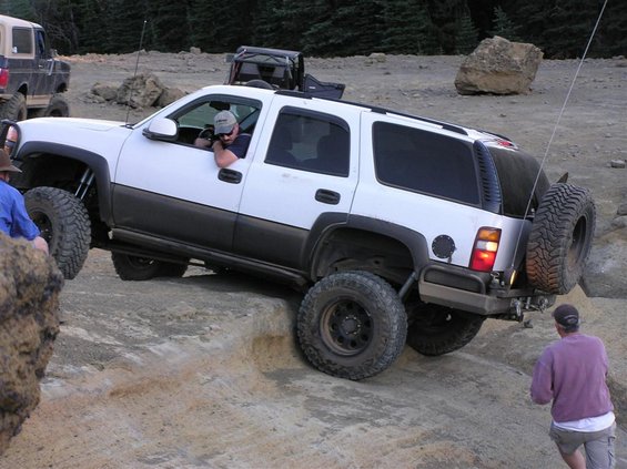 White 2002 GMC Yukon off-roading on rocks