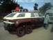 1994 Ford Bronco - Custom 6-wheeled van with a roof rack and a red gas can is parked outdoors.