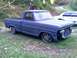 2002 Ford Crown Victoria - A gray Ford pickup truck sits on grass, missing its grille and sporting custom wheels.