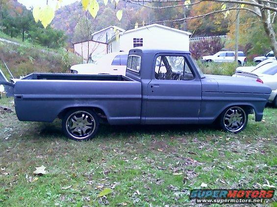 Dark gray pickup truck, side view, custom wheels, lowered stance