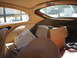 1962 Jaguar XKE - The interior of a car shows tan upholstery, a newspaper, and boxes, with a dark SUV visible outside.