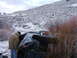 1992 Ford Ranger - A pickup truck has overturned in a snowy, brushy area with a person inspecting the damage.