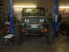 1994 Jeep YJ - A green Jeep Wrangler is shown on a lift in a workshop, equipped with a front-mounted winch.