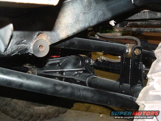 Undercarriage view of vehicle suspension and differential with Supermotors.net logo