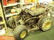 1985 Suzuki QUADRUNNER 250/LT250 - This 1985 Suzuki QUADRUNNER 250/LT250 ATV is stored indoors, appearing to be in a state of disrepair or undergoing maintenance.