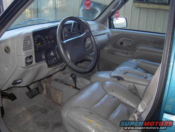 Interior of a 1995 GMC Suburban showing the dashboard, steering wheel, seats, and gear shifter