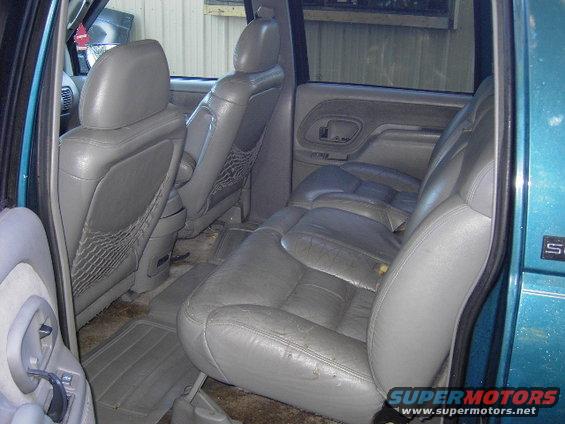 Teal 1995 GMC Suburban interior with gray leather seats and a visible 'S' badge on the exterior door frame