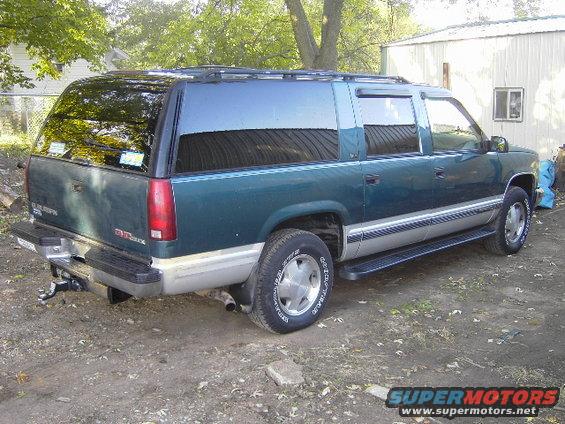 1995 GMC Suburban SUV, rear 3/4 view, green with silver trim