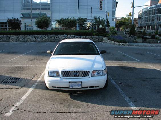 White 2003 Ford Crown Victoria parked in a lot, front view