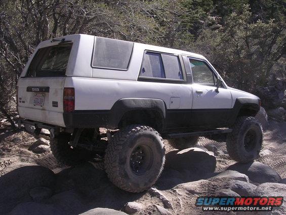 White 1985 Toyota 4Runner with camper shell on rocky trail