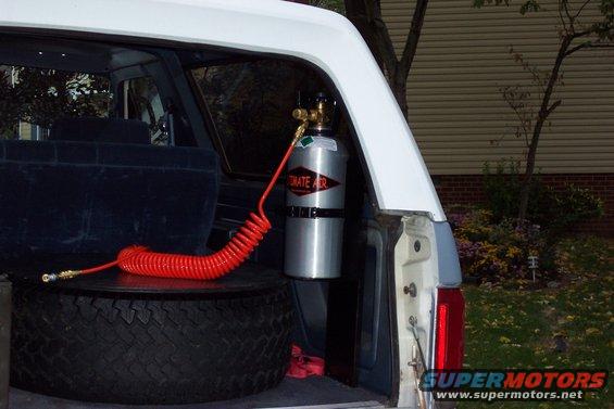Spare tire in cargo area with air compressor tank and hose attached