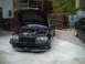 2006 Volkswagen GTI - A black car with its hood open, revealing the engine bay, parked outdoors. Another vehicle is partially visible on the right side.