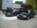2006 Volkswagen GTI - Two black sedans are parked outdoors with their hoods open, revealing their engines.