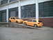 2006 Volkswagen GTI - Two yellow Volkswagen Golf Mk4 hatchbacks are parked on a ramp outside an industrial building.