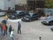 2006 Volkswagen GTI - A gathering of people are seen near several cars in an outdoor industrial area.